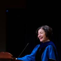 Provost Mili smiling at the podium